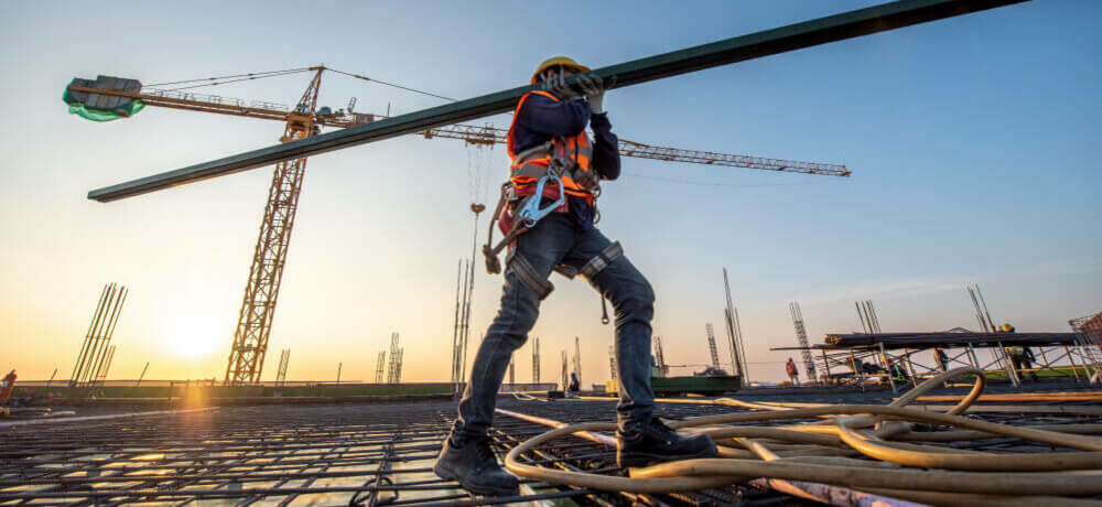 Skilled tradesman carrying metal beam